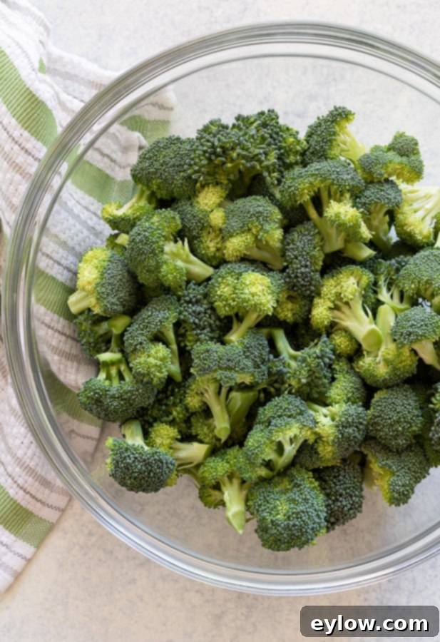 Raw broccoli florets in a glass bowl.