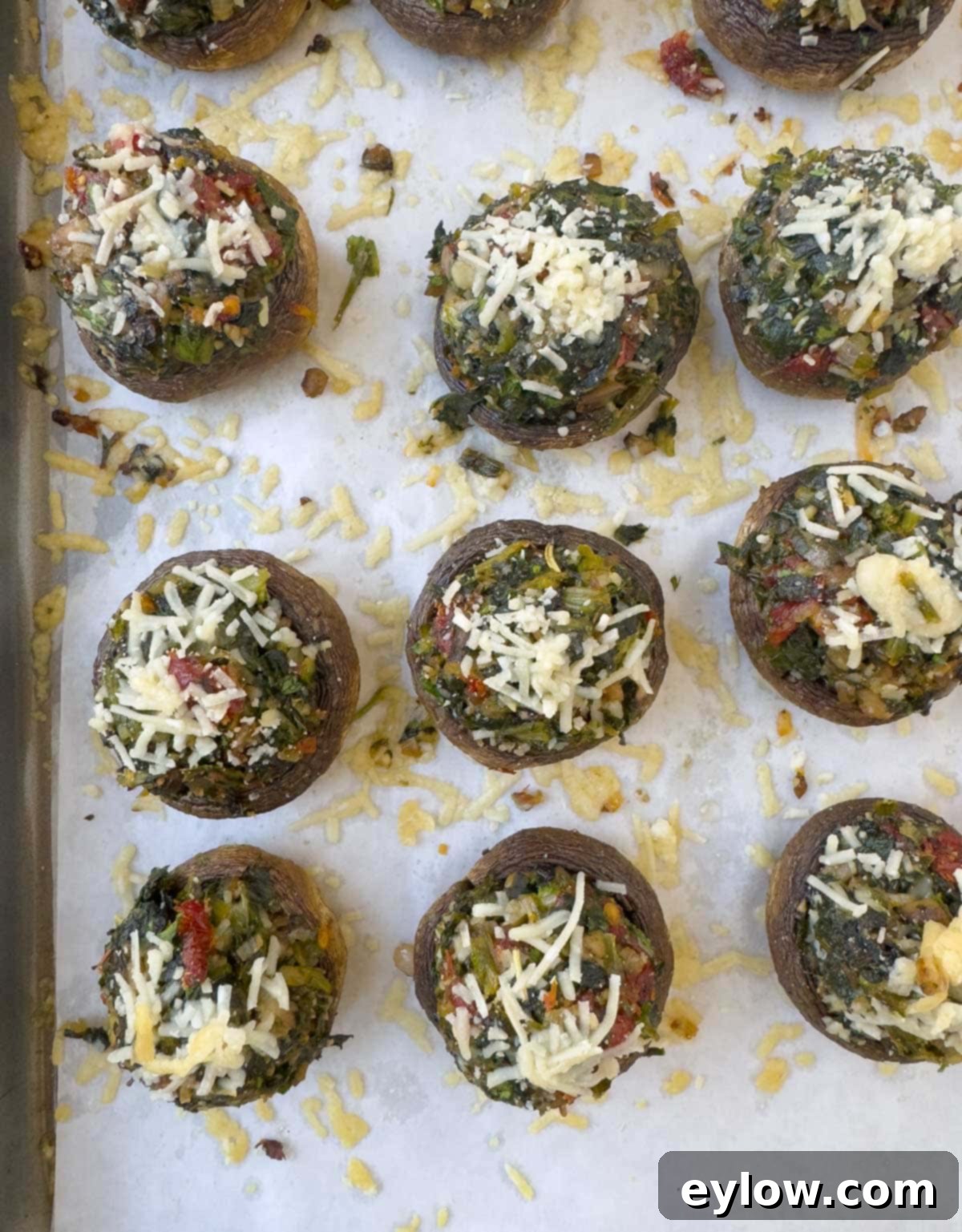 A baking tray showcasing perfectly baked stuffed mushrooms, glistening with melted Parmesan cheese and a golden-brown finish, ready to be served.