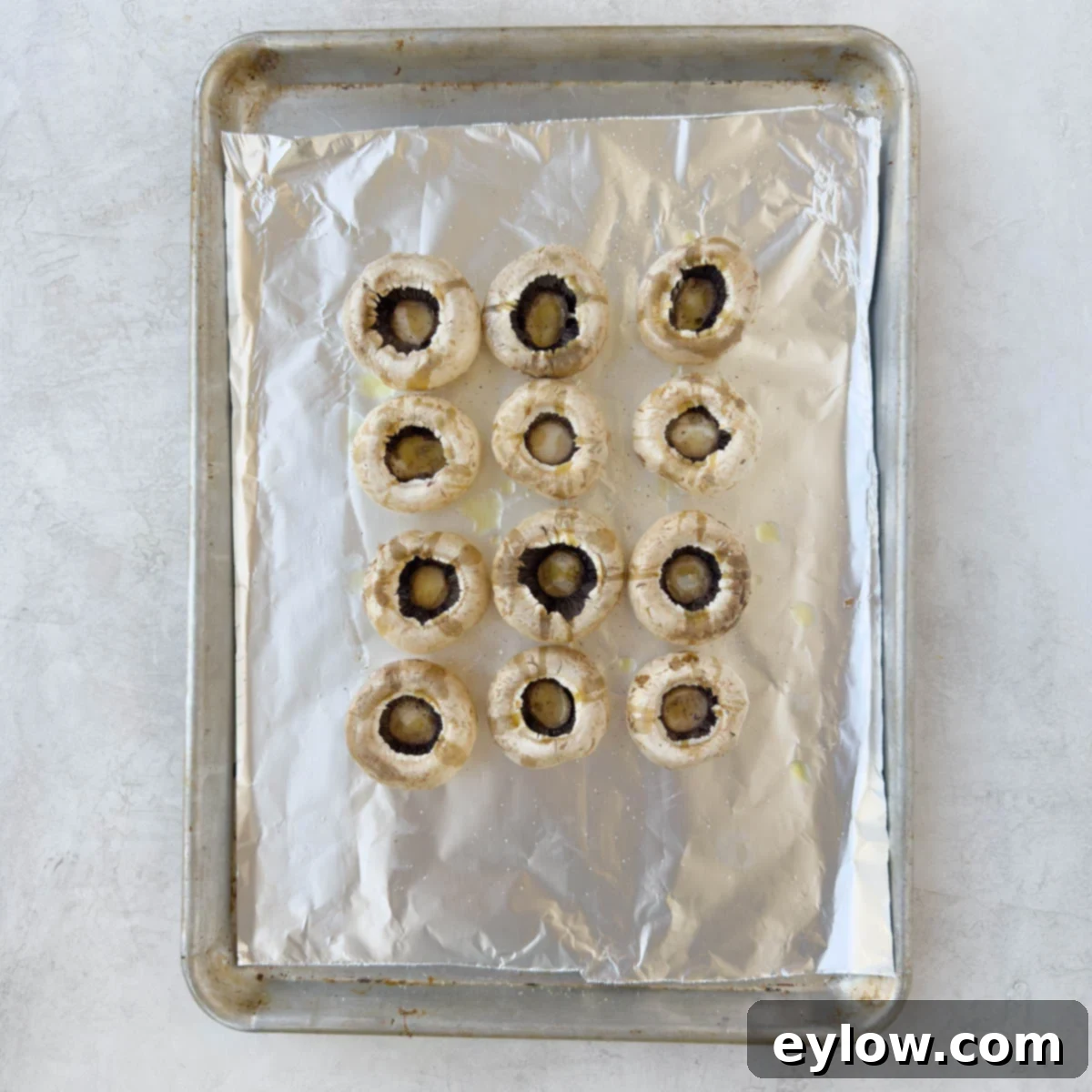 Large, cleaned mushroom caps, hollow side up, arranged on a foil-lined baking sheet, drizzled with olive oil and seasoned.