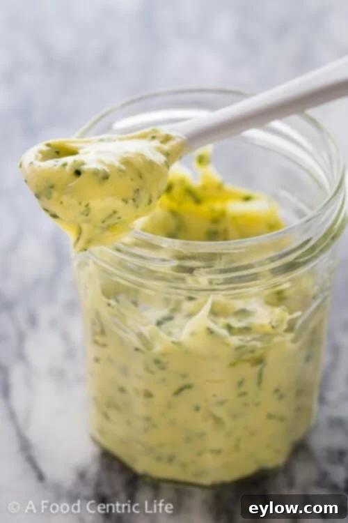 A jar of homemade mayonnaise with herbs.