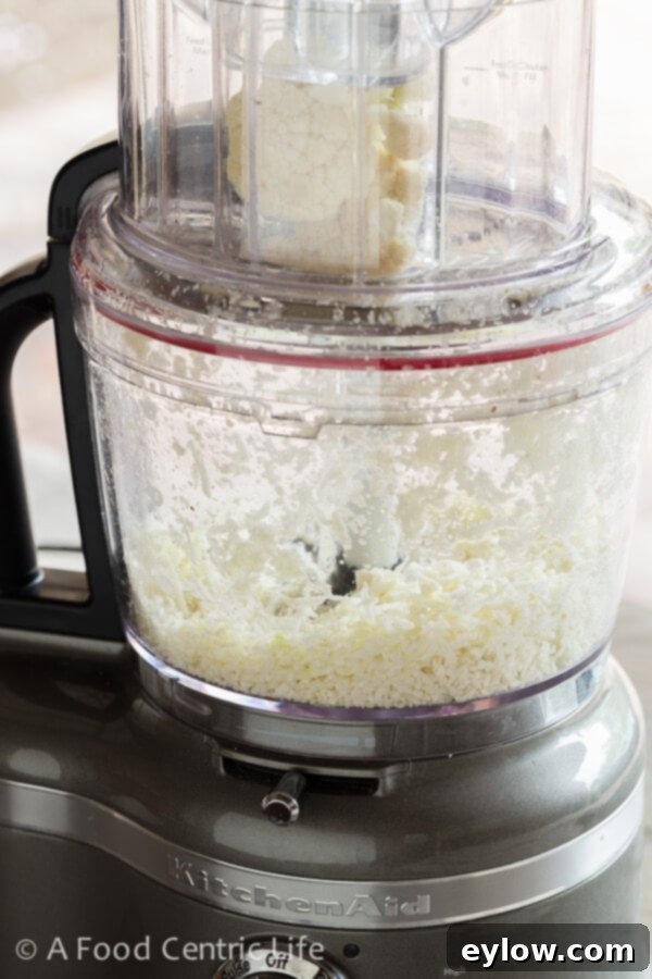 Creamy Cheesy Cauliflower Rice 4 Making cauliflower rice with a food processor.