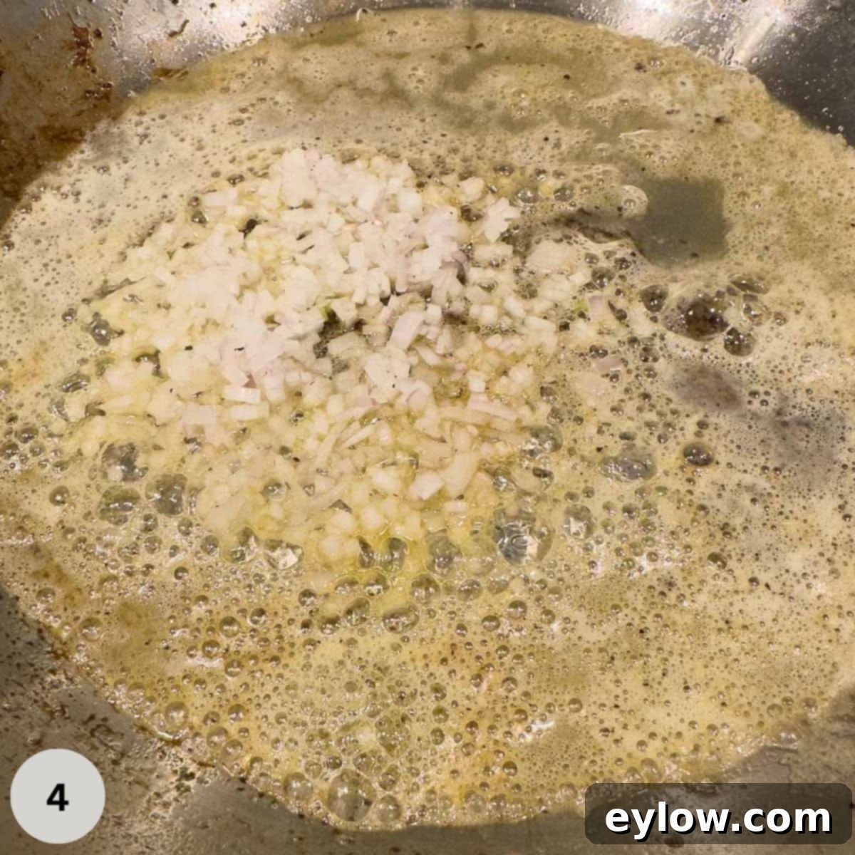 Chopped shallots sautéing in butter starting a pan sauce.