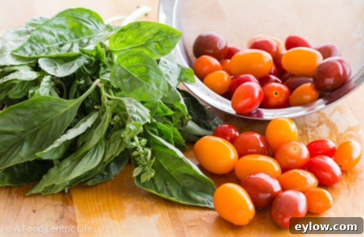 Quick Caprese Bites with Homemade Basil Vinaigrette 3 Basil leaves and red and yellow cherry tomatoes for Caprese skewers.
