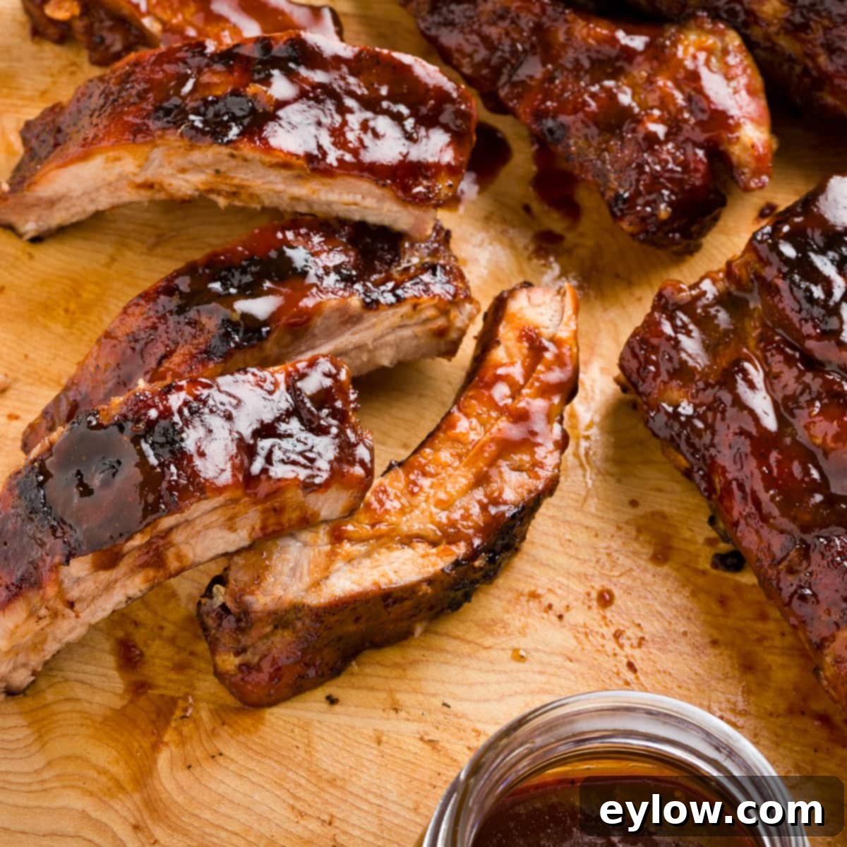 Homemade Gluten-Free Hoisin 7 Oven baby back ribs glazed with rich brown hoisin sauce in a cutting board.