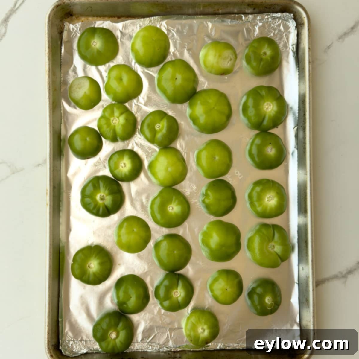 Washed and halved tomatillos ready for the broiler on foil. 