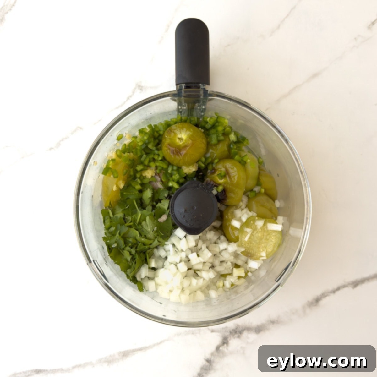 Ingredients for salsa verde in a food processor bowl.