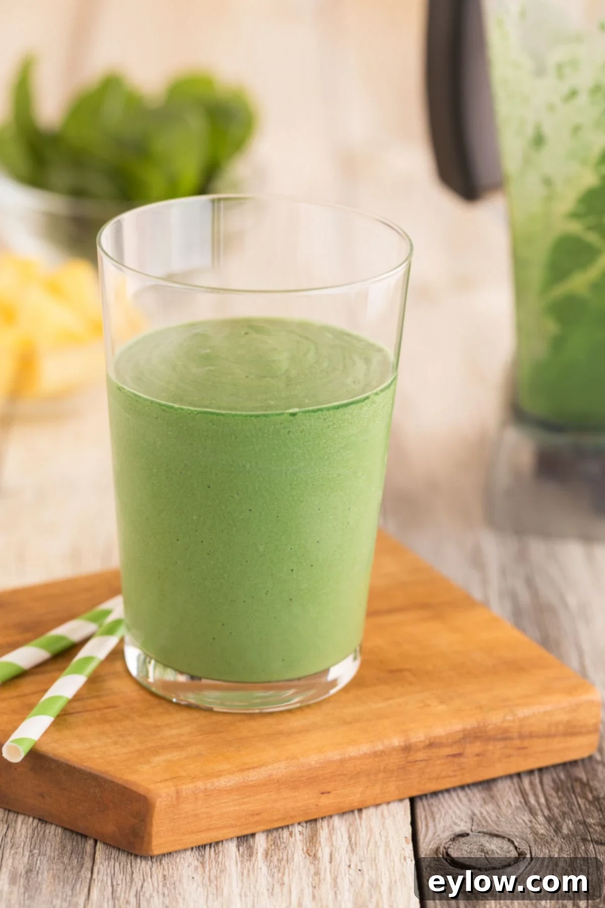 Revitalizing Green Detox Smoothie 2 Bright green detox smoothie with tropical flavors of coconut, pineapple, and green from spirulina, garnished with a mint sprig.