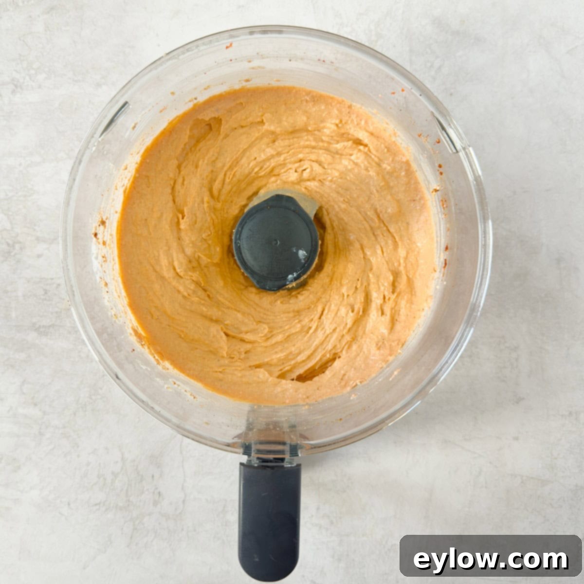 Ultimate Creamy Smoked Salmon Dip 5 The food processor bowl now contains a creamy, pale orange smoked salmon dip, perfectly pureed and ready to be tasted.