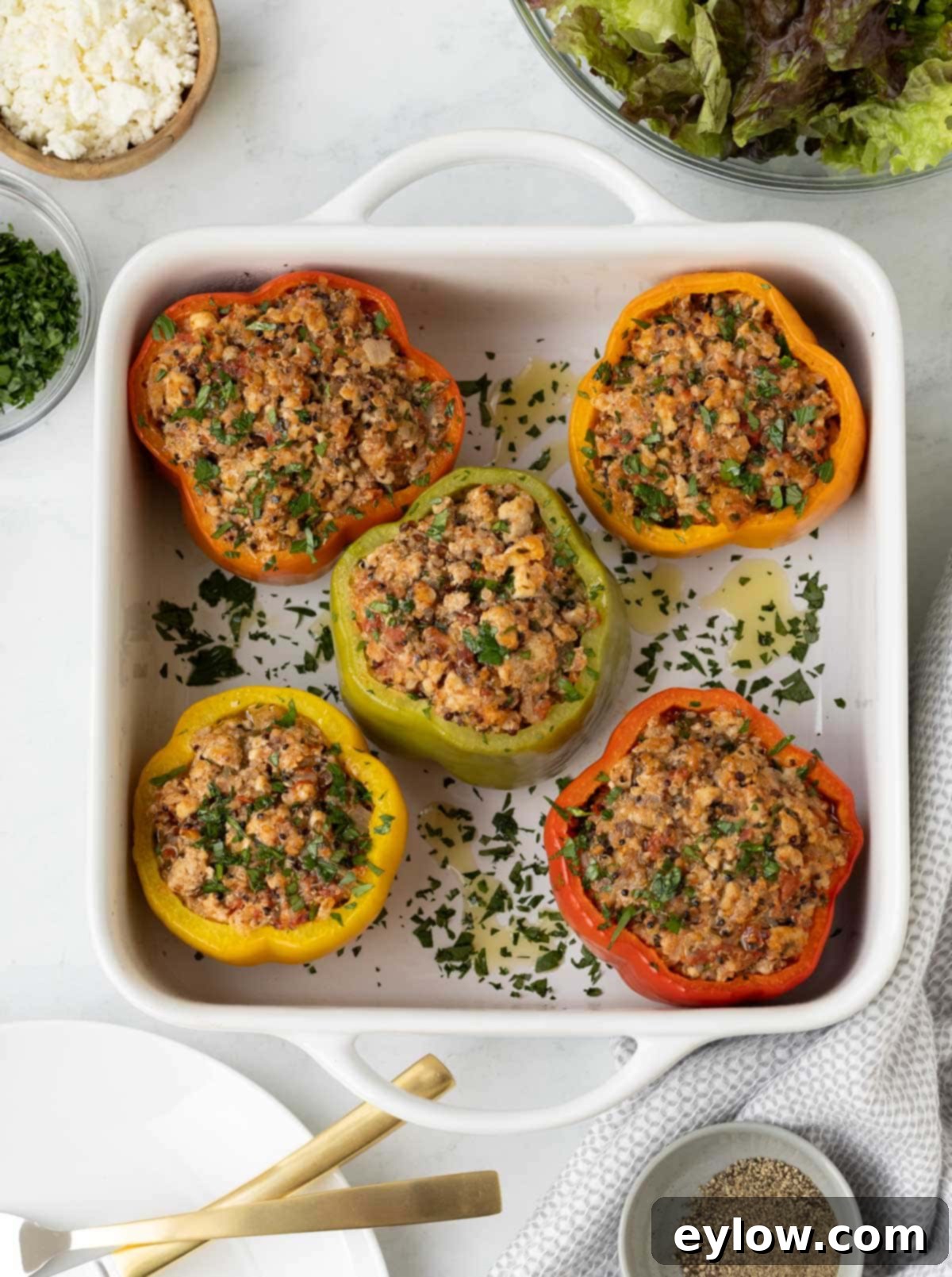 Flavorful Turkey Stuffed Pepper Boats 2 Red, yellow, green, and orange stuffed peppers in a white baking dish, ready to be served.