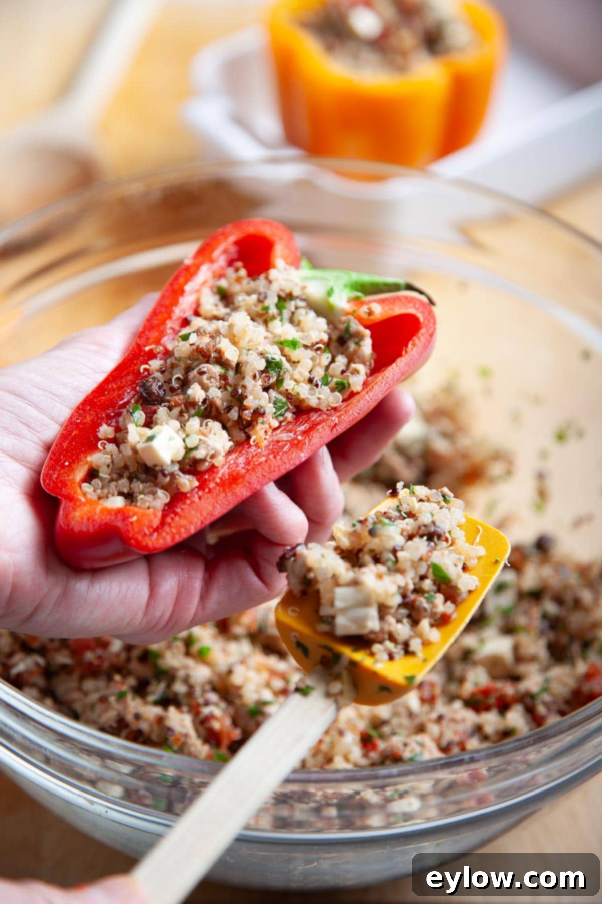 Turkey and Quinoa Stuffed Bell Peppers -4381 Two long red bell peppers, cut in half lengthwise and stuffed with savory ground meat and cheese, presented in a baking dish.