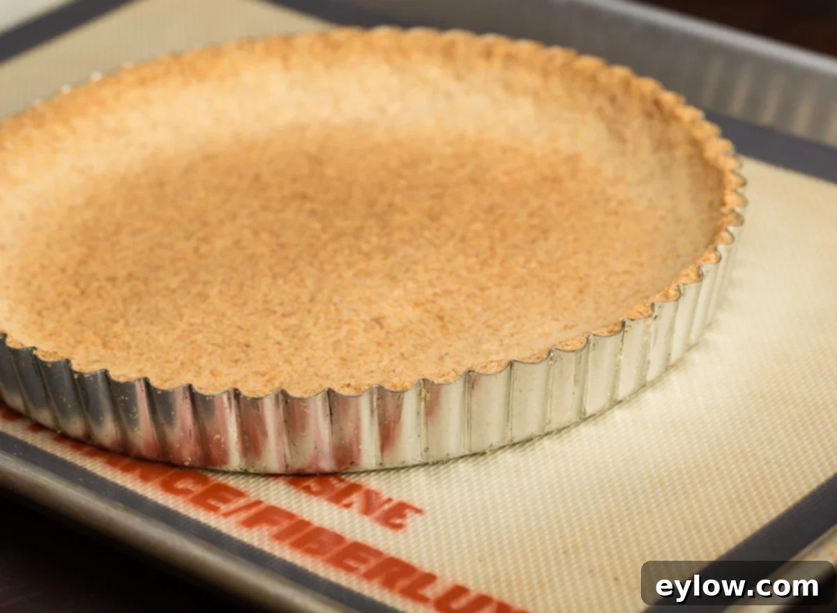 A light golden baked gluten-free tart shell made with almond and coconut flour, perfectly cooled and ready for filling.