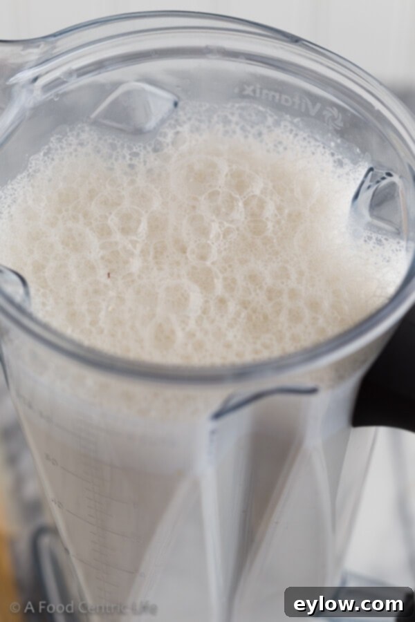Creamy Homemade Cashew Milk 4 Frothy homemade cashew milk being blended in a high-speed blender.
