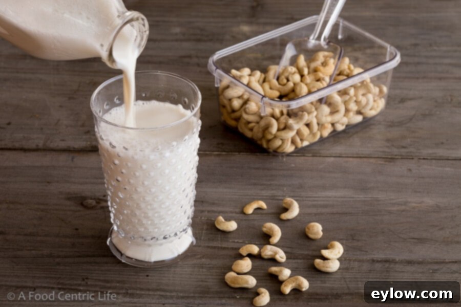Creamy Homemade Cashew Milk 5 Pouring a glass of homemade non-dairy cashew milk, showcasing its inviting appearance.