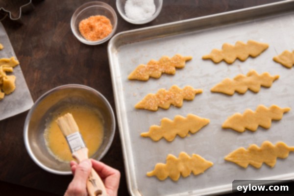 Cut out cookies on a baking sheet, brushed with egg wash and sprinkled with colored sugar.