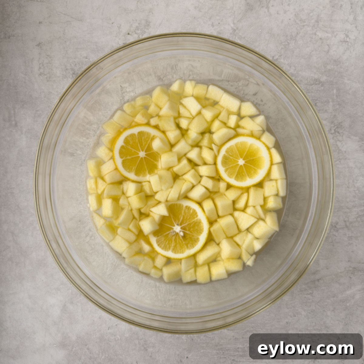 Peeled and chopped apples in lemon water to prevent browning.