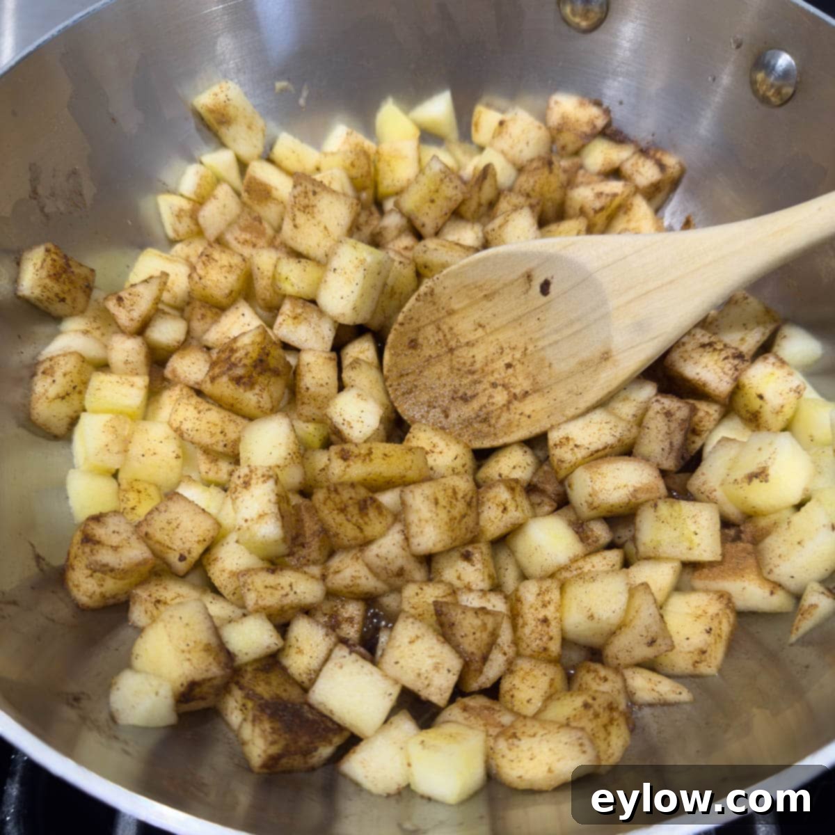 Apple chunks cooking in a pan with spices. 