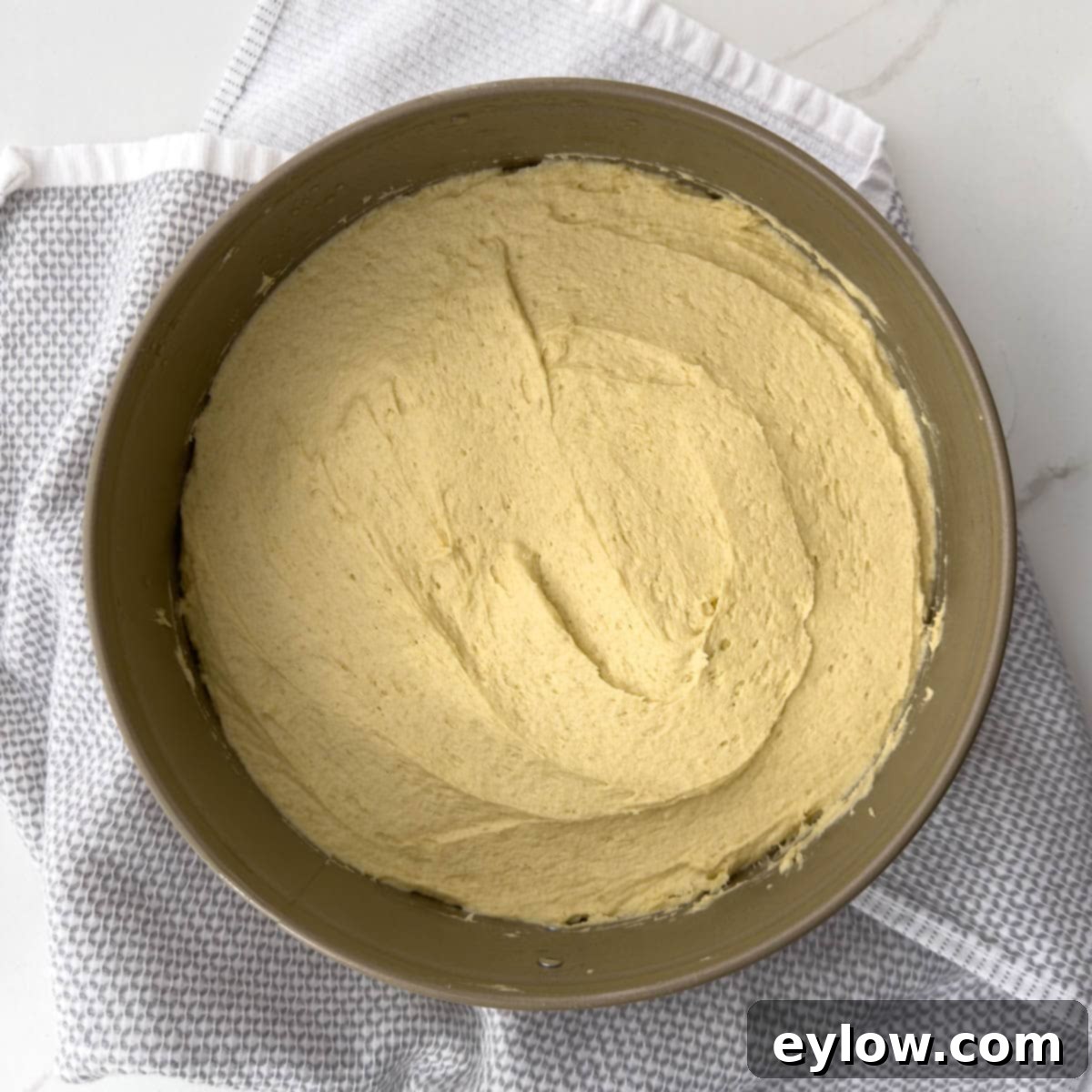 Cake batter spread into a springform pan for baking.