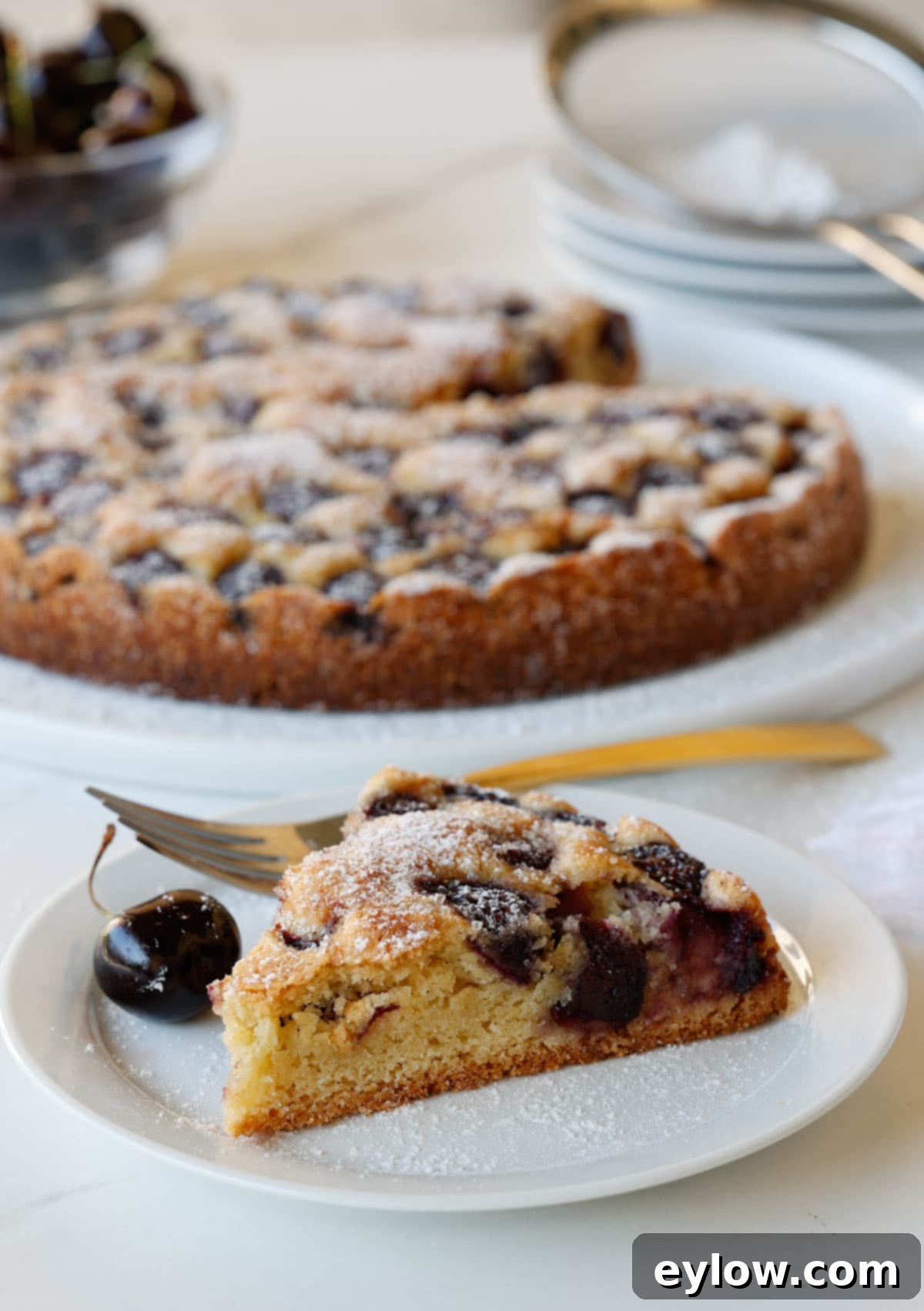 Baked cherry cake with a slice on a small plate.