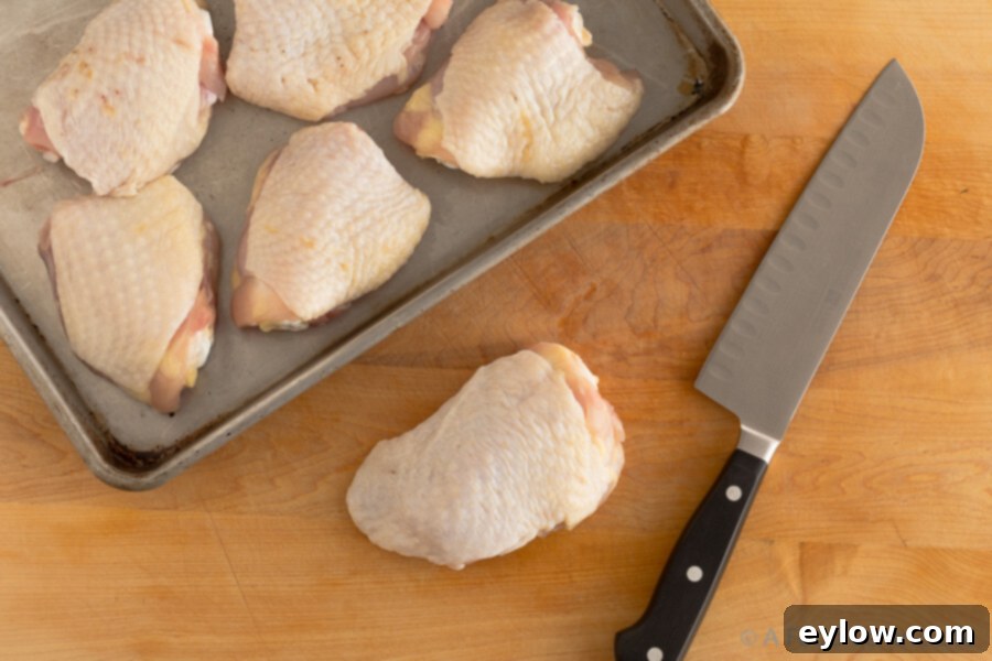 Raw chicken thighs trimmed and seasoned, ready for browning