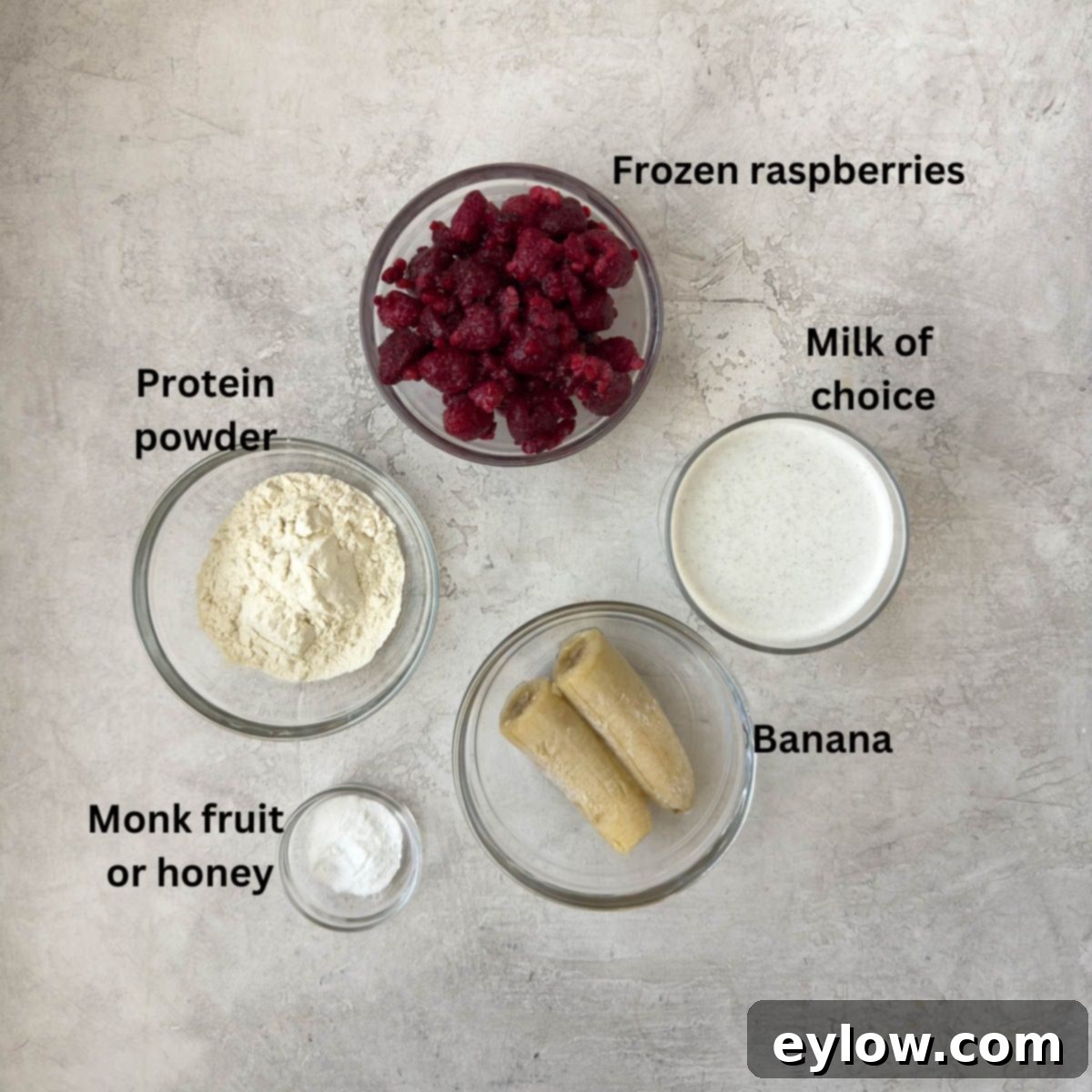 Ingredients for a raspberry smoothie in glass bowls. 