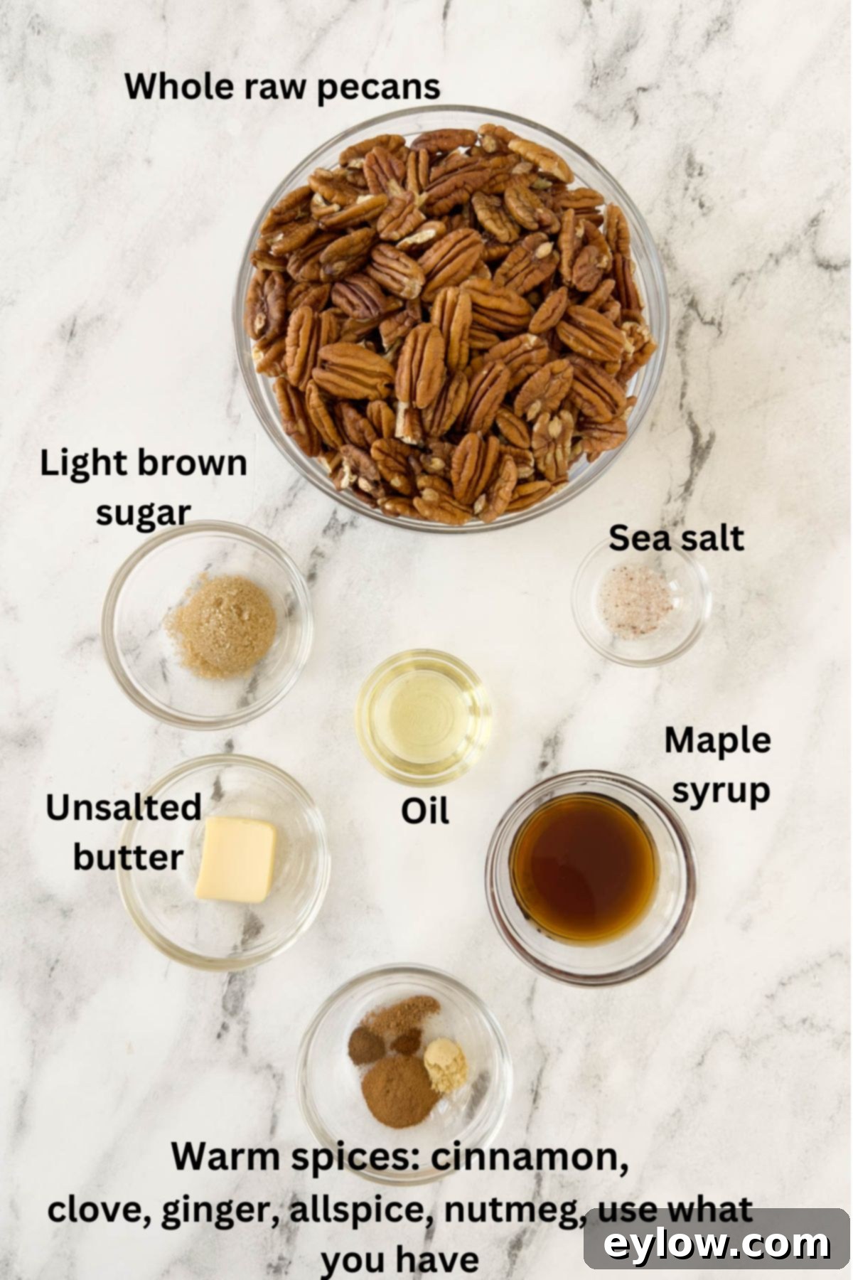 Ingredients for making candied maple pecans in prep bowls on a marble counter, clearly labeled.