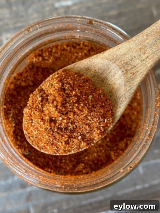 Spice dry rub on a spoon over a jar of the rub.