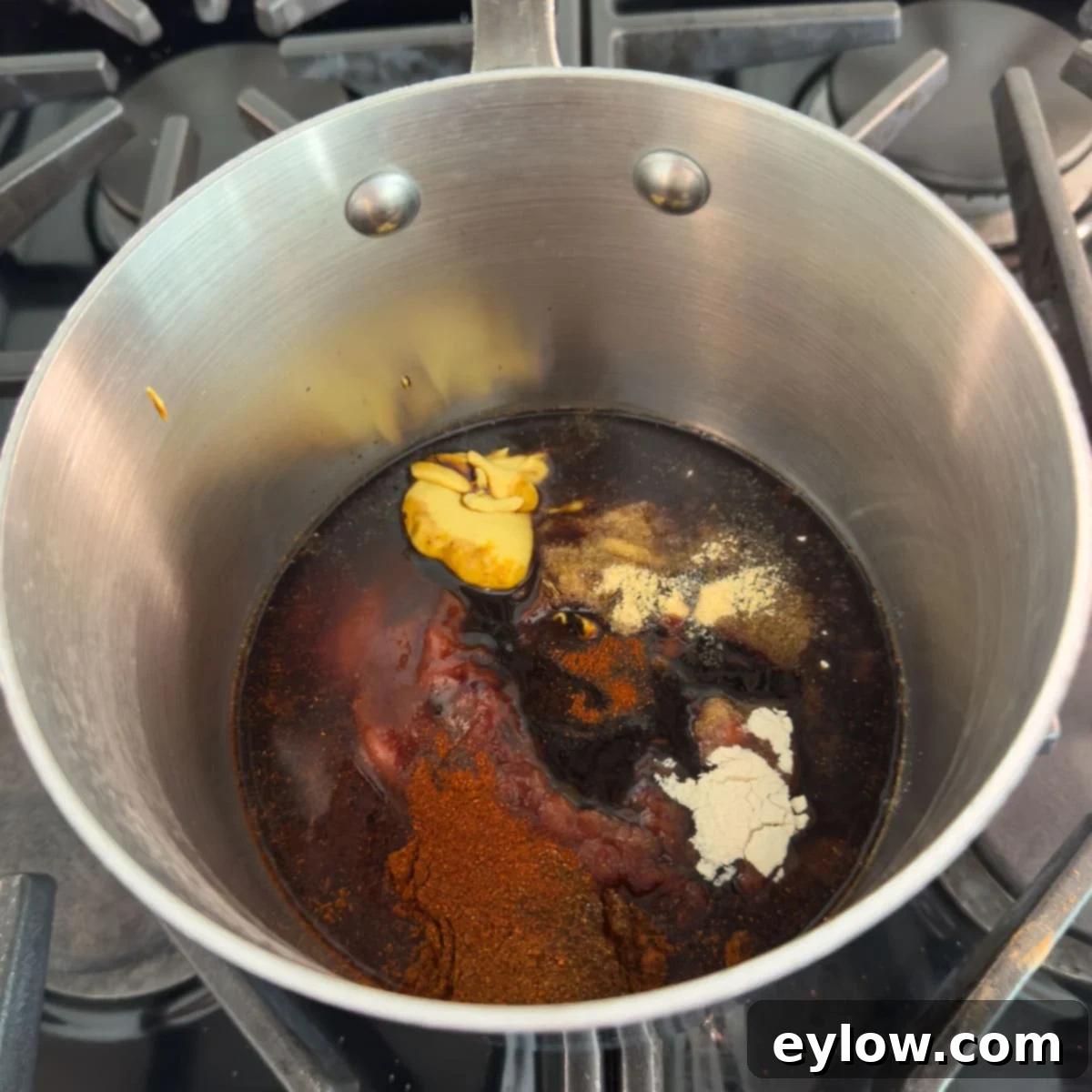Ingredients for gluten-free bbq sauce in a small steel pan cooking.