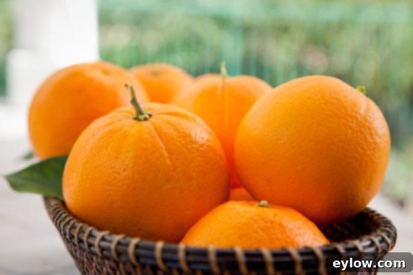 Fresh oranges, an essential ingredient for a vibrant orange almond torte, are shown on a cutting board, ready for zest and juice. | AFoodCentricLife.com