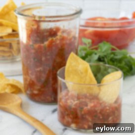 Smoked salsa in a tall jar and a small serving glass cup with corn chips
