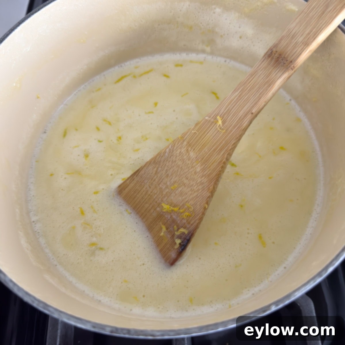 Simply Divine Lemon Posset 5 A pot of heavy cream and lemon zest on the stovetop.