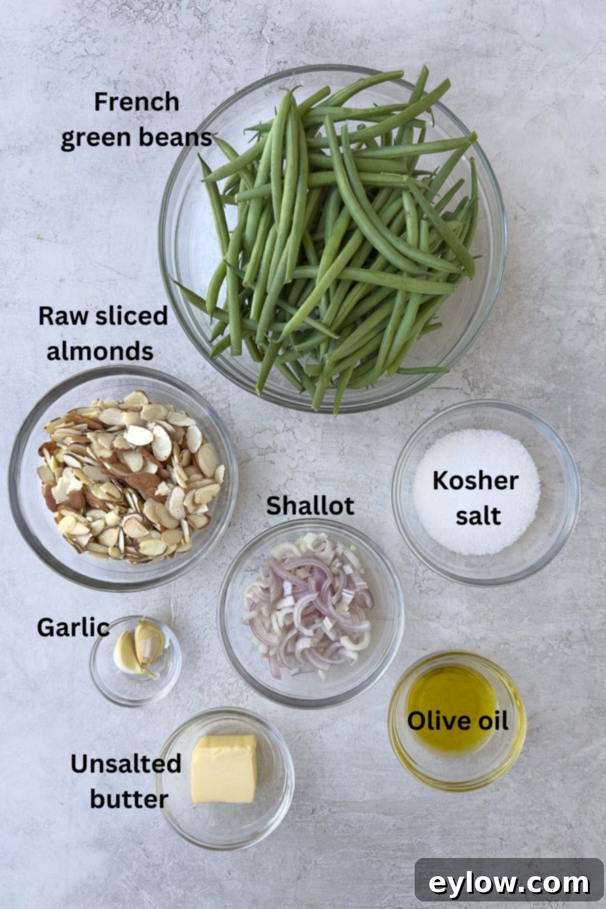 Ingredients for green beans recipe in bowls on the counter. 