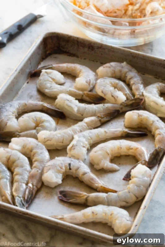 A tray of raw cleaned shrimp getting ready to be cooked. 