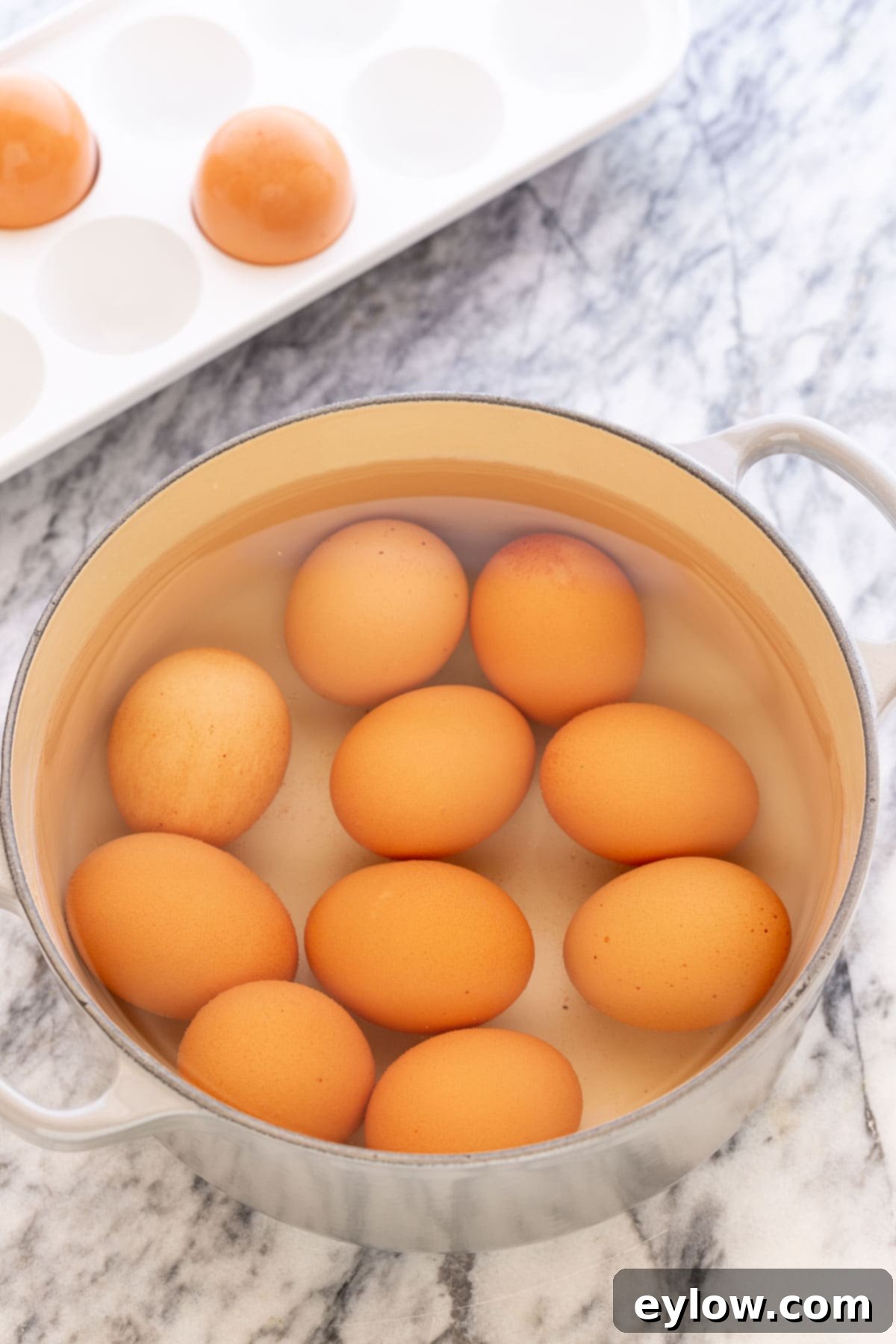 Flawless Hard Boiled Eggs That Peel Effortlessly 3 A pot of cooked brown hard-boiled eggs cooling on the counter, ready for their ice bath.