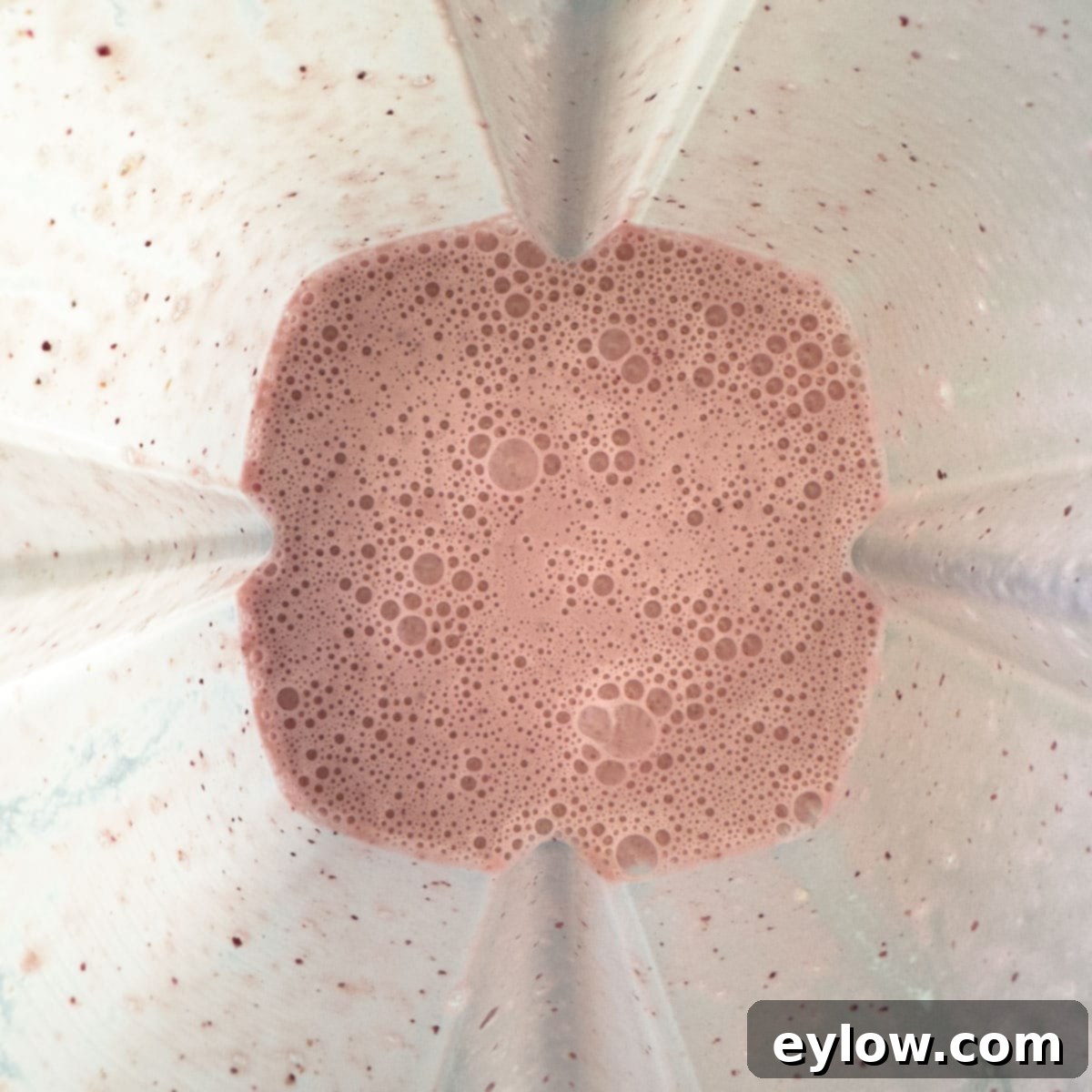 Easy 5-Minute Cherry Smoothie 5 A pink and bubbly blended cherry smoothie in a blender container, ready to be poured.