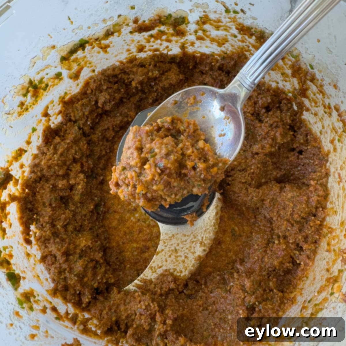 Velvety Sun-Dried Tomato Pesto Pasta 4 Rich reddish brown sun-dried tomato pesto on a spoon.