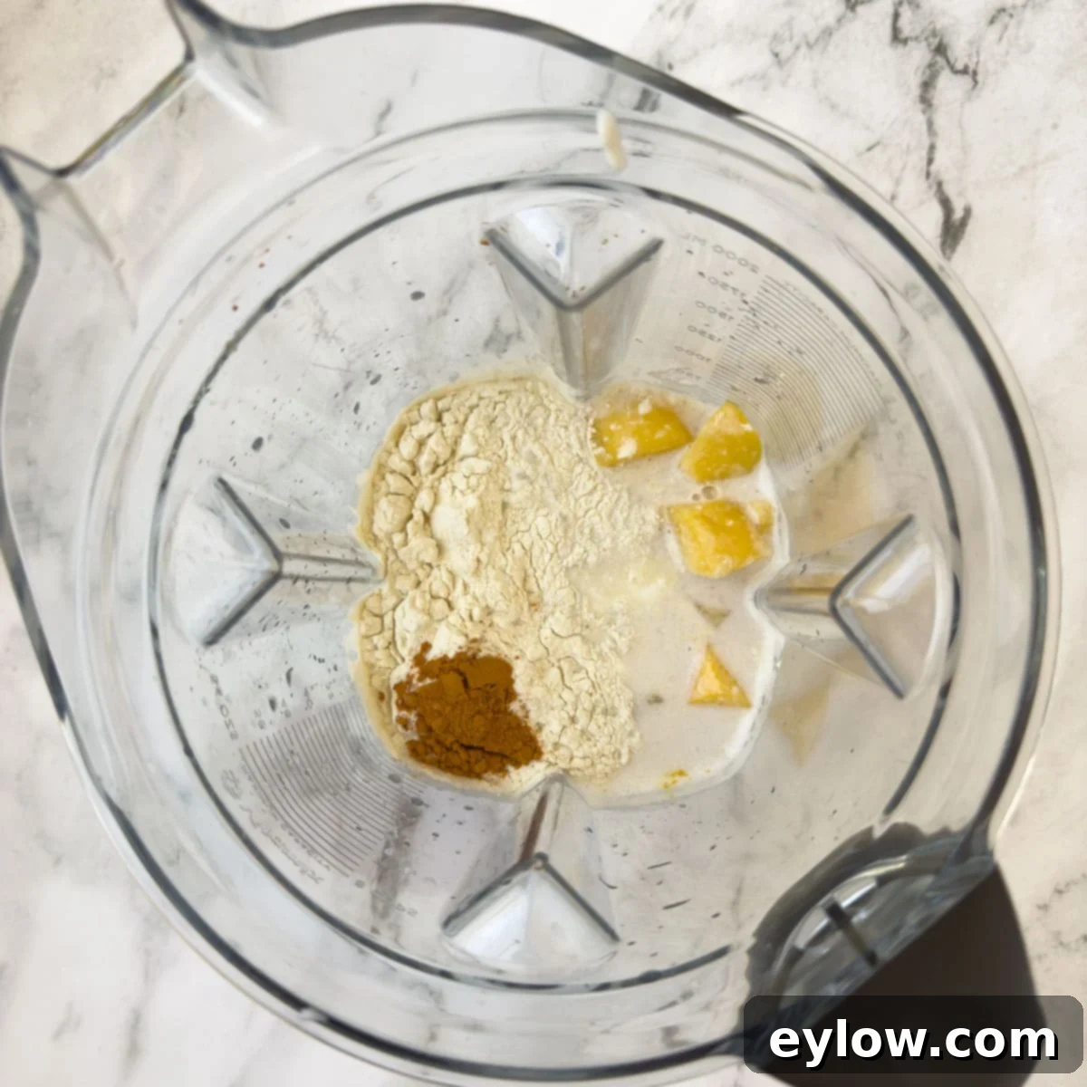 A blender container with ingredients for a smoothie.