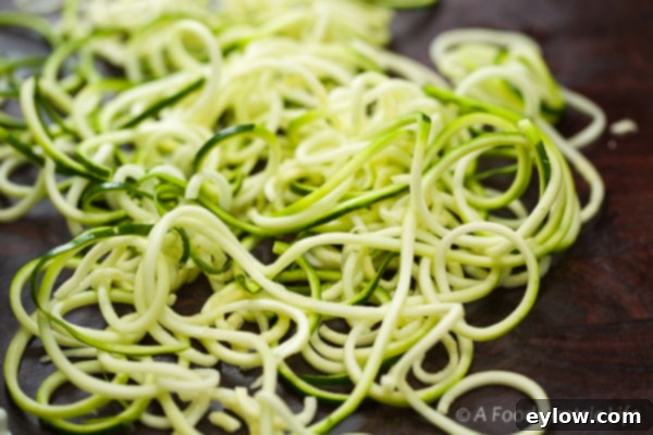A spiralizer in action, making zucchini noodles.