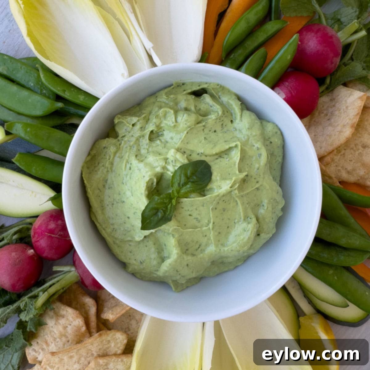 Creamy Avocado Basil Yogurt Dip 7 Close up of creamy basil and avocado dip in white bowl.