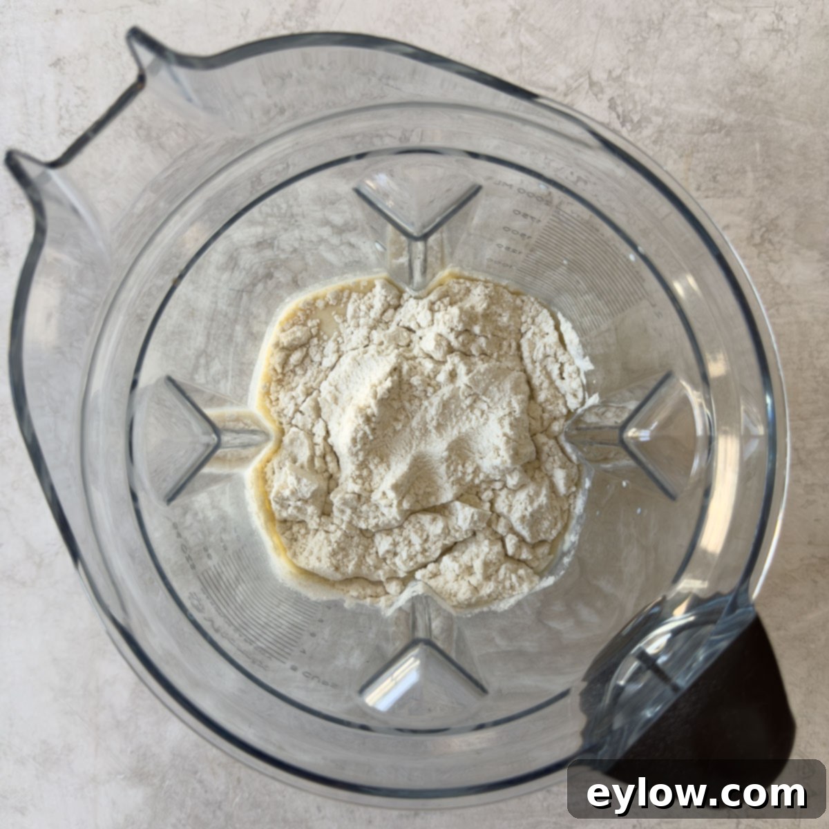 All crepe batter ingredients including flour, eggs, milk, and vanilla, inside a blender container, ready to be blended.