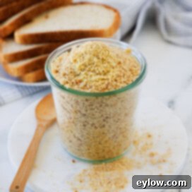 A tall jar with golden crunchy breadcrumbs piled high and overflowing, ready for use in recipes.
