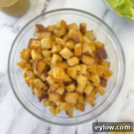 A bowl of golden baked croutons in a glass bowl on a counter.