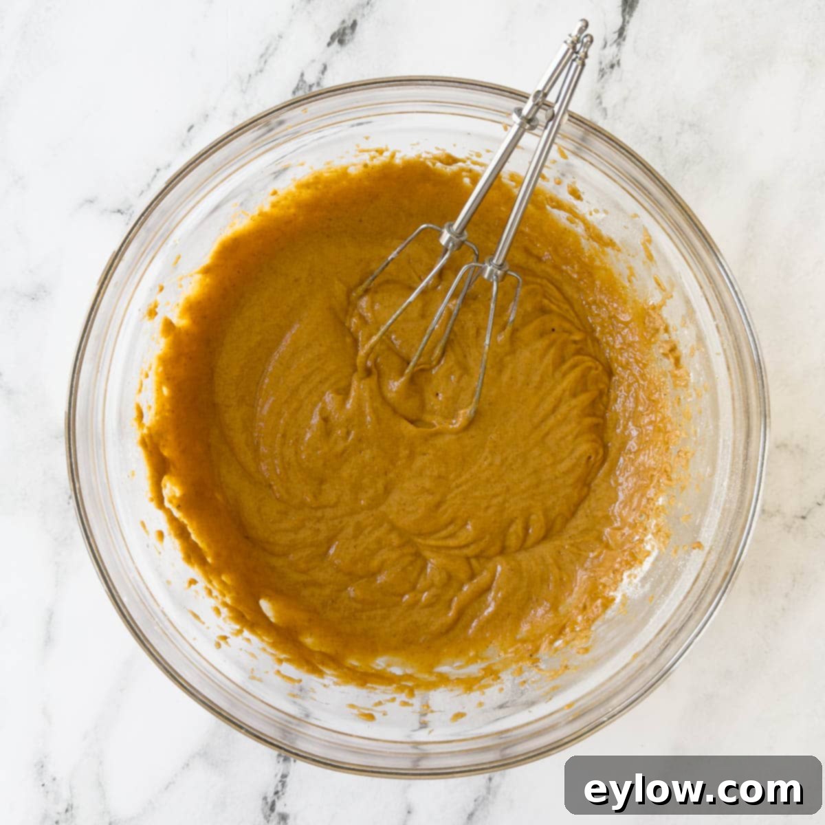 The perfectly smooth and creamy finished pumpkin bread batter, showcasing its rich orange hue and ready consistency, waiting to be transferred to the baking pan.
