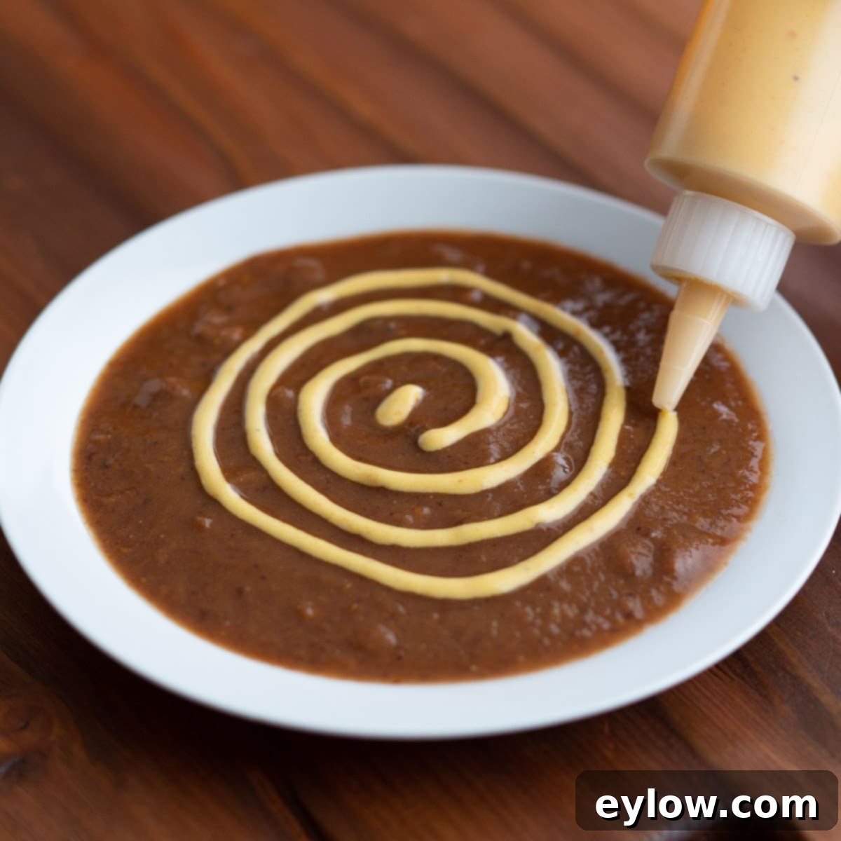 Soup Spider Web-1 Drawing circles with sauce on top of soup to make a web design.