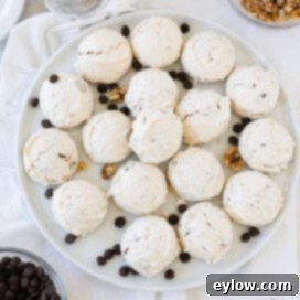A round white plate piled high with golden-brown chocolate chip meringue cookies, ready to be served.