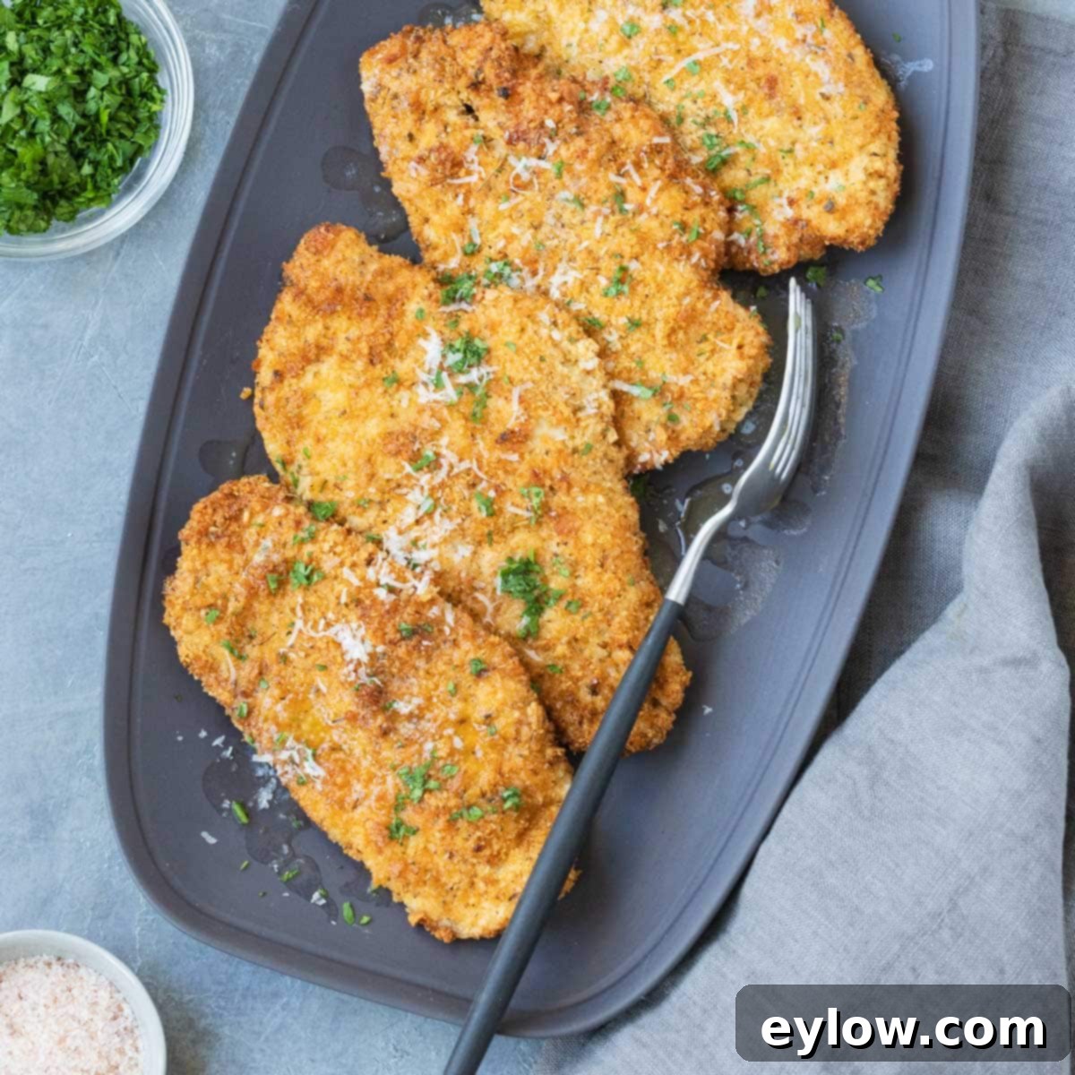 Crispy golden air fryer chicken cutlets on a gray serving platter.