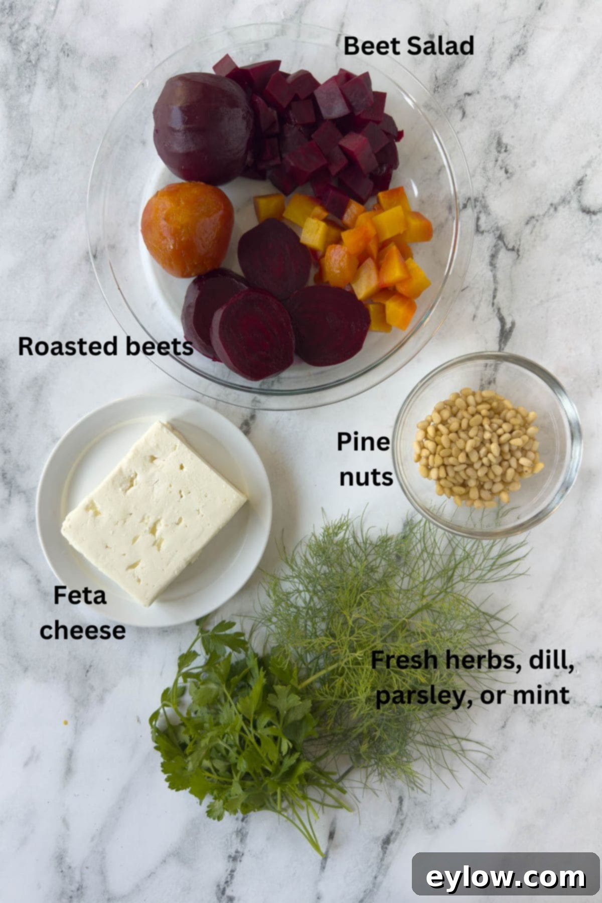 Fresh red and golden beets, bundles of aromatic herbs, creamy feta cheese, and various nuts arranged neatly on a kitchen counter, ready for the beet salad preparation.