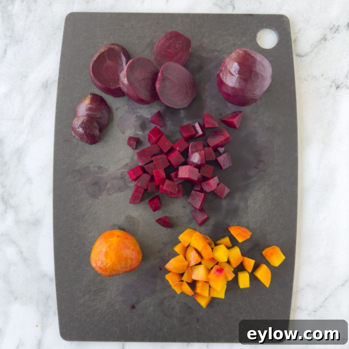 Vibrant red and golden beets being expertly chopped into uniform cubes on a sleek black cutting board, ready for the beet salad.