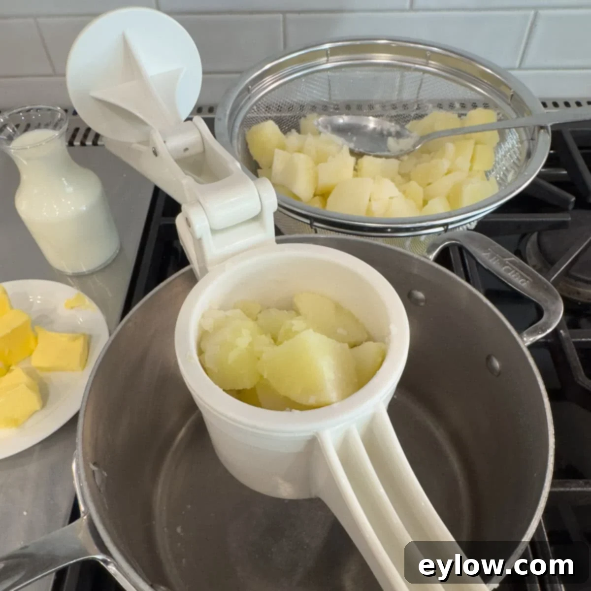 A potato ricer with a hopper full of cooked potatoes. 