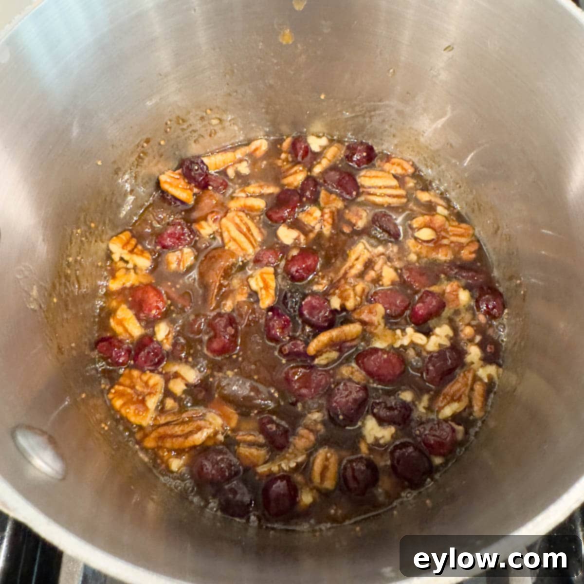 Effortless Baked Brie with Jam 6 Fig jam topping with dried fruit and nuts simmering in a small pot