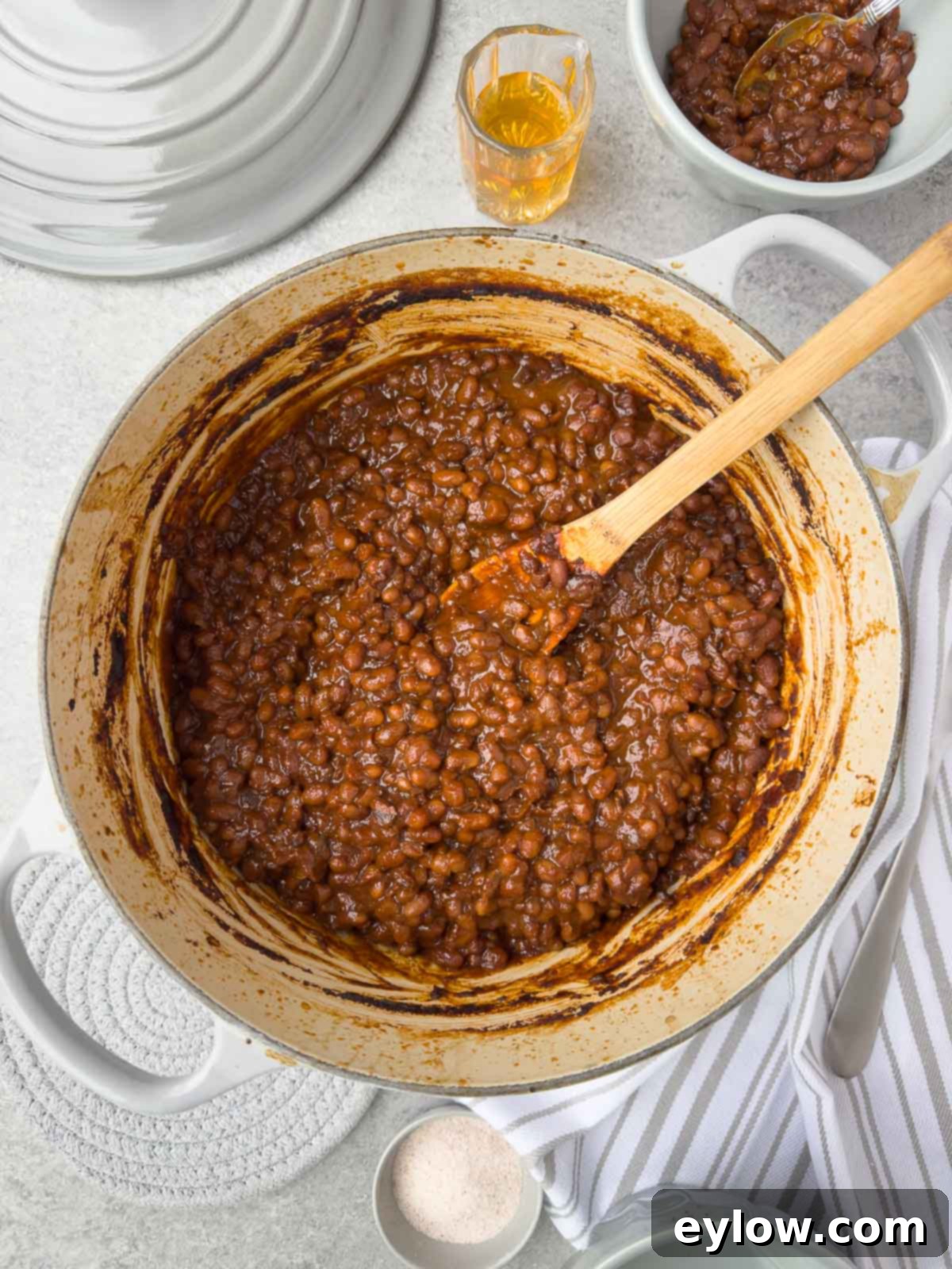 A gray Dutch oven filled with glistening, deep brown Boston baked beans, ready to be served.